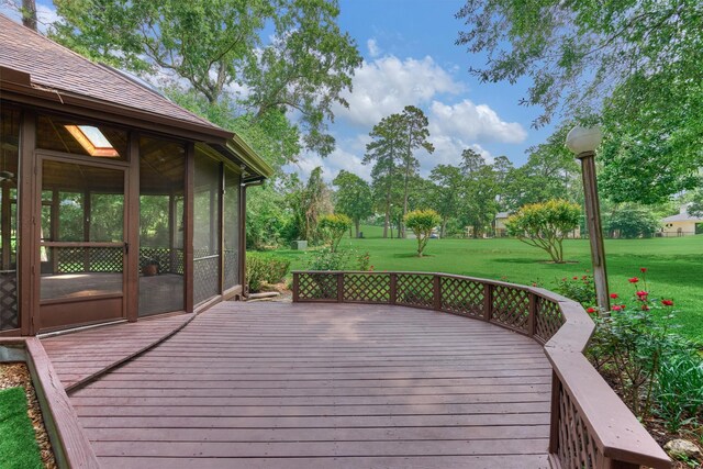 wooden deck with a lawn and a sunroom