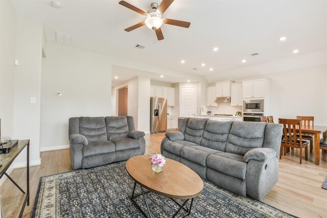 2379 Woodland Prairie Ln, Conroe, TX 77384 - living area featuring light wood-style floors, a ceiling fan, baseboards, recessed lighting, and visible vents