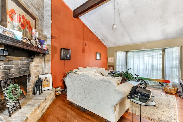 living area featuring visible vents, high vaulted ceiling, wood finished floors, and a fireplace