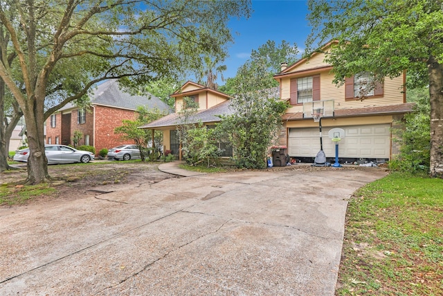 view of front of property featuring driveway, an attached garage, and a chimney