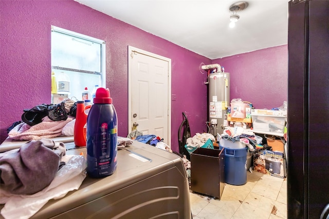 laundry room with water heater, a textured wall, and laundry area