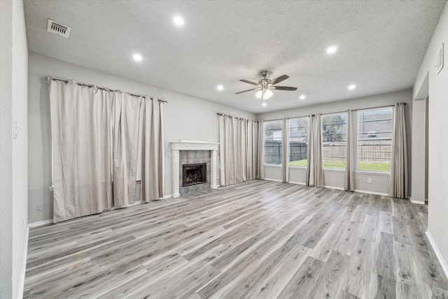 unfurnished living room featuring a textured ceiling, ceiling fan, visible vents, recessed lighting, and wood finished floors