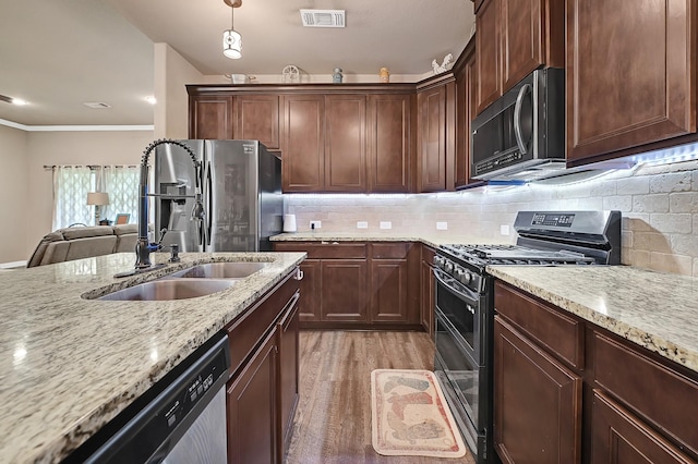 kitchen with visible vents, stainless steel appliances, backsplash, and light stone counters