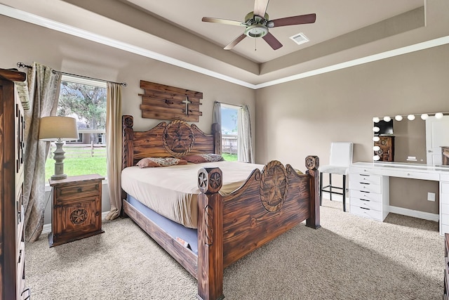 bedroom with a raised ceiling, visible vents, ceiling fan, and carpet floors