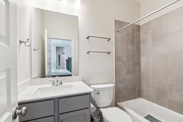 ensuite bathroom with connected bathroom, toilet, shower / tub combination, and vanity