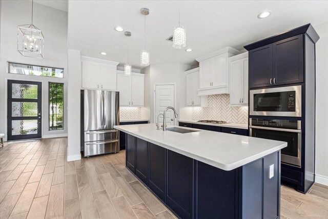 kitchen with a sink, appliances with stainless steel finishes, tasteful backsplash, and recessed lighting