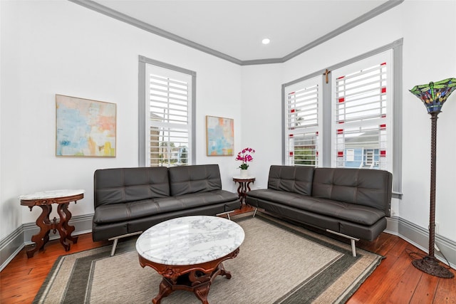 living area with recessed lighting, hardwood / wood-style flooring, crown molding, and baseboards