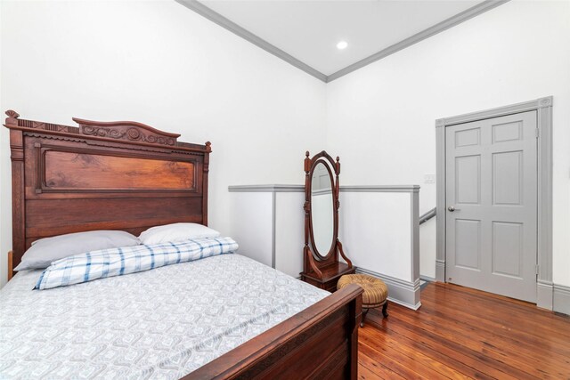 bedroom featuring ornamental molding, recessed lighting, wood finished floors, and baseboards