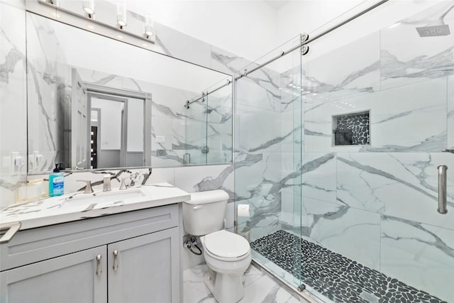 full bathroom with a marble finish shower, toilet, vanity, and marble finish floor