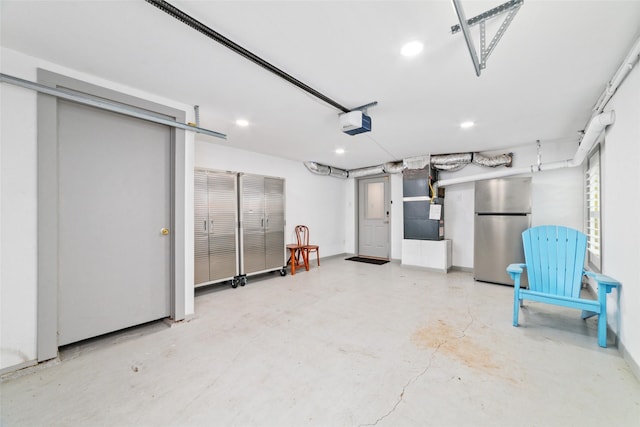 garage featuring a garage door opener, heating unit, recessed lighting, and freestanding refrigerator
