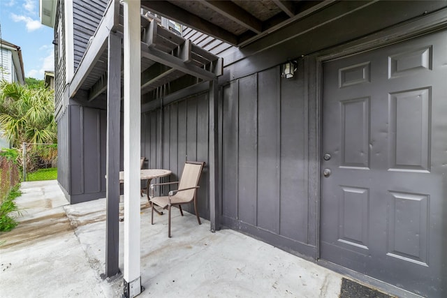 property entrance featuring a patio, fence, and board and batten siding