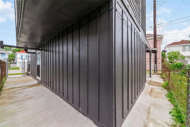 view of property exterior featuring fence, board and batten siding, and a gate