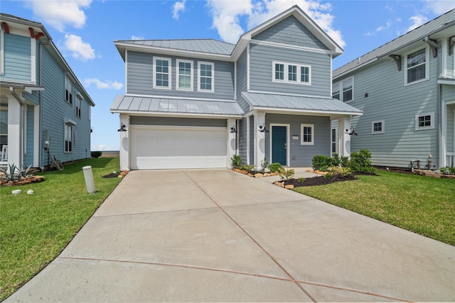 traditional-style home with metal roof, a front yard, concrete driveway, and a garage