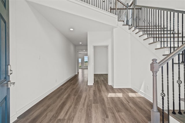 foyer entrance with stairway, wood finished floors, recessed lighting, and baseboards