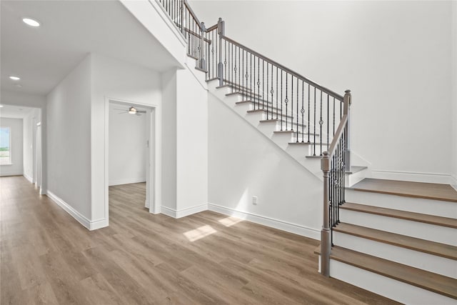 stairs featuring recessed lighting, ceiling fan, wood finished floors, and baseboards