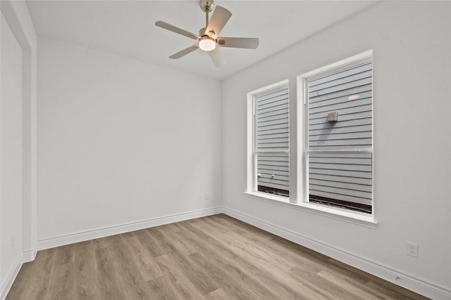 unfurnished room with ceiling fan, wood finished floors, and baseboards