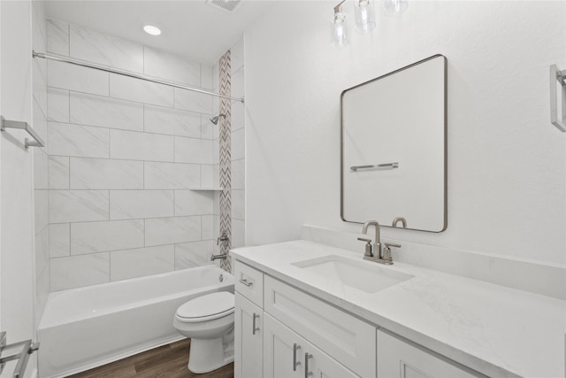 bathroom featuring toilet, recessed lighting, wood finished floors, vanity, and bathtub / shower combination