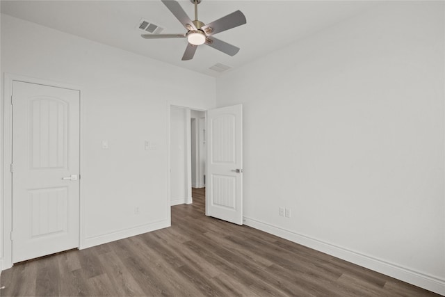 unfurnished bedroom featuring a ceiling fan, visible vents, wood finished floors, and baseboards