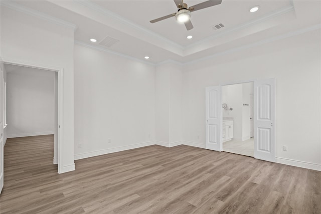 unfurnished bedroom featuring recessed lighting, light wood-type flooring, visible vents, crown molding, and a tray ceiling