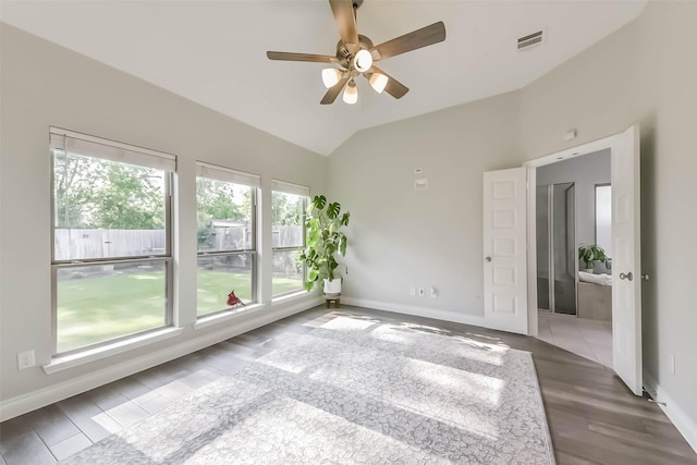 unfurnished room with ceiling fan, baseboards, lofted ceiling, and visible vents