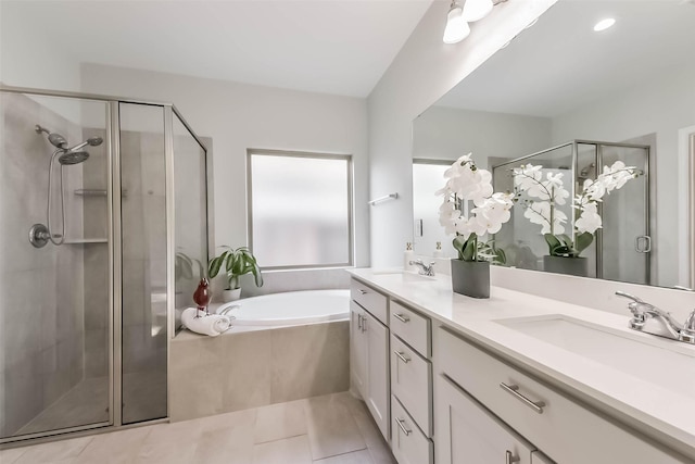full bath with double vanity, a shower stall, a bath, and a sink