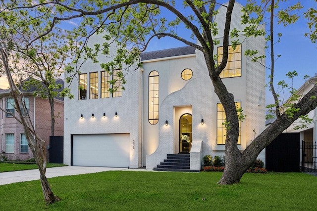 view of front of home with a front lawn, concrete driveway, brick siding, and a garage