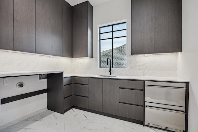 kitchen featuring marble finish floor, a sink, modern cabinets, and light countertops