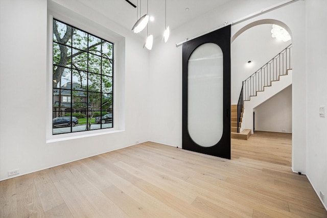 spare room with stairway and wood finished floors