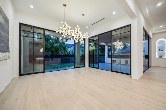 unfurnished room featuring wood finished floors, recessed lighting, and a chandelier
