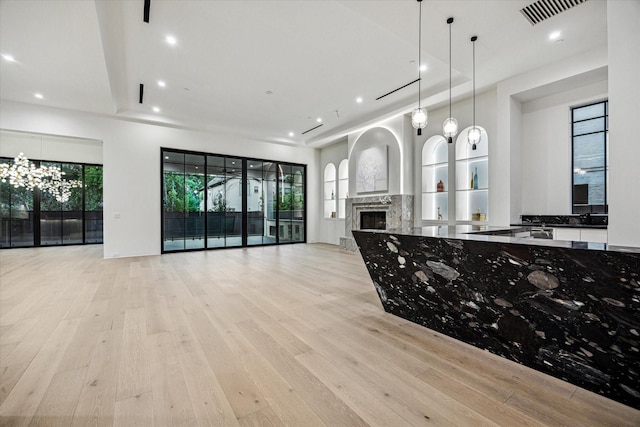 kitchen with a fireplace, recessed lighting, open floor plan, and light wood-style floors