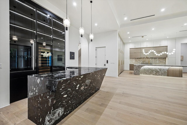 kitchen featuring a spacious island, recessed lighting, decorative light fixtures, and light wood-style flooring
