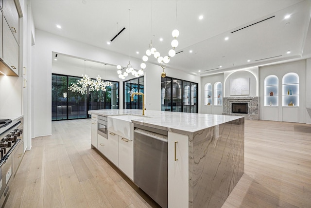 kitchen featuring a sink, modern cabinets, white cabinetry, stainless steel dishwasher, and a large island with sink