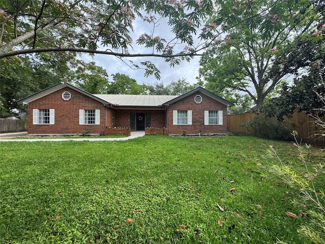 ranch-style house featuring brick siding, fence, and a front yard