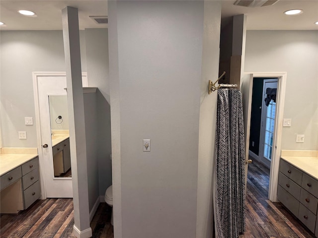 bathroom featuring vanity, toilet, wood finished floors, and visible vents
