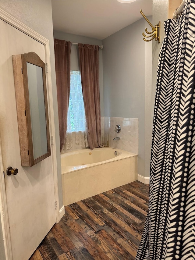 full bathroom featuring a shower with shower curtain, wood finished floors, and a garden tub