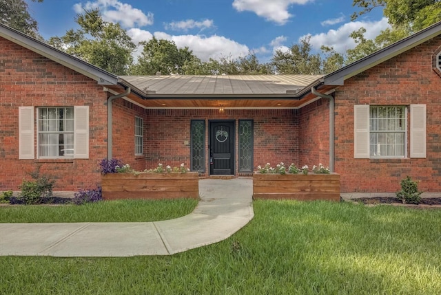 9010 Carousel Ln, Houston, TX 77080 - property entrance with a lawn, a metal roof, and brick siding