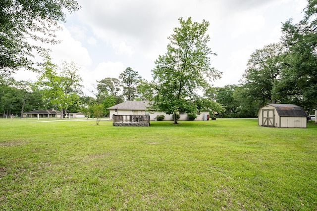 view of yard featuring an outbuilding, a storage shed, and a wooden deck