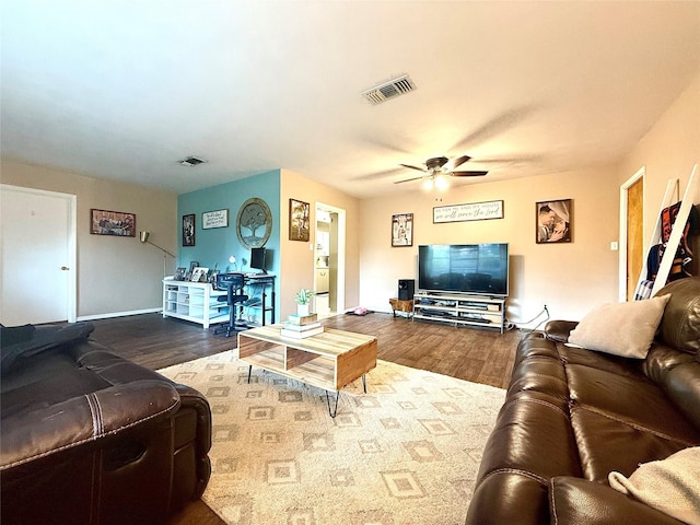 living room featuring wood finished floors, visible vents, and a ceiling fan