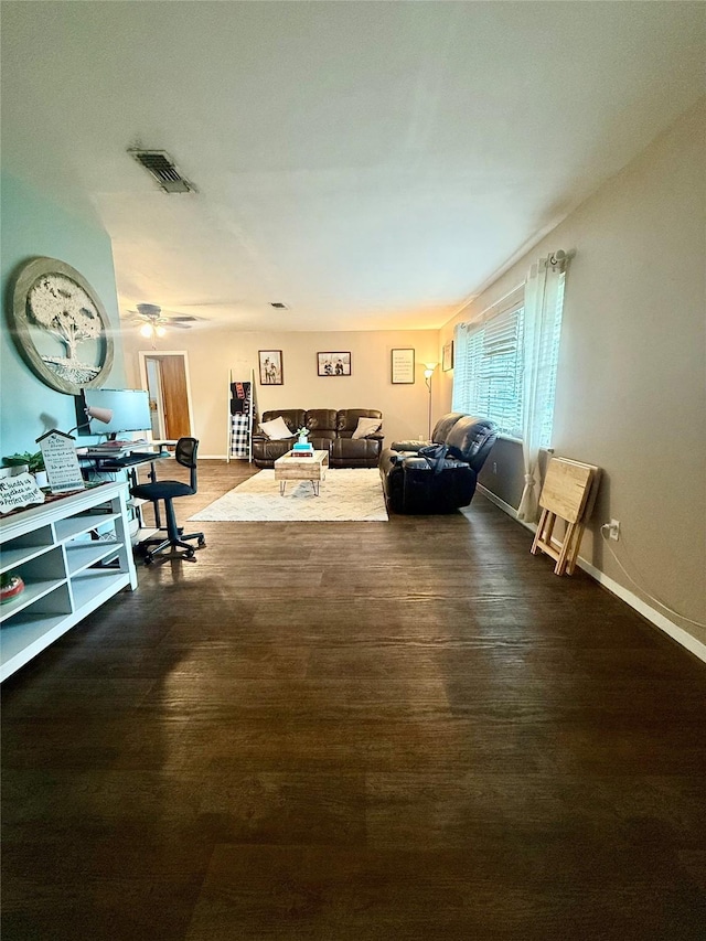 living area featuring visible vents, wood finished floors, and baseboards
