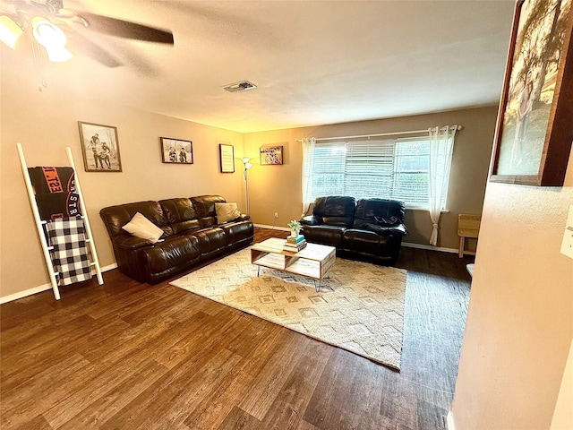 living room featuring wood finished floors, visible vents, a ceiling fan, and baseboards