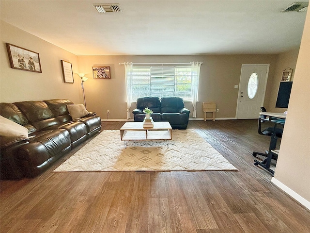 living room with visible vents, wood finished floors, and baseboards