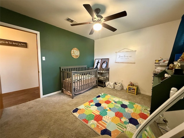 carpeted bedroom with a ceiling fan, visible vents, and baseboards