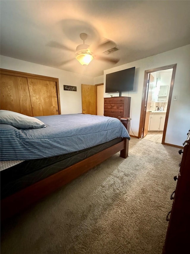 bedroom with connected bathroom, light carpet, ceiling fan, baseboards, and visible vents