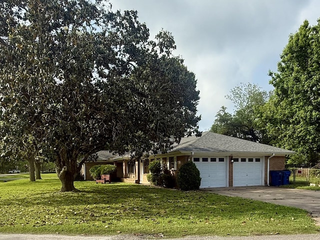 view of front of house featuring a front lawn, concrete driveway, brick siding, and an attached garage
