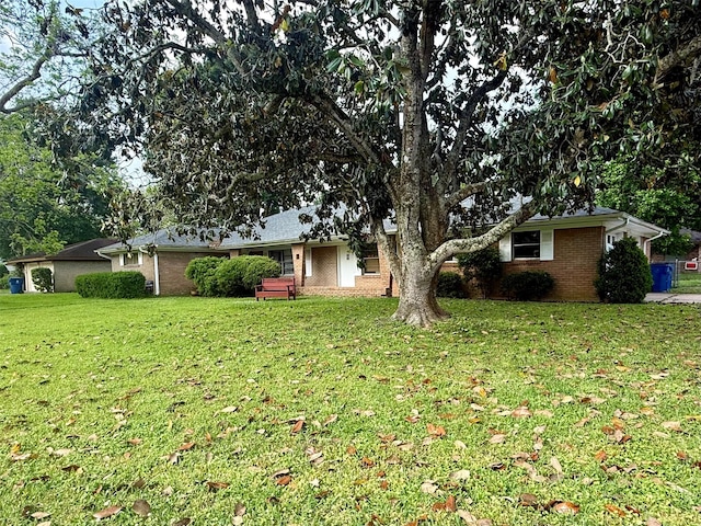 exterior space featuring brick siding and a front lawn