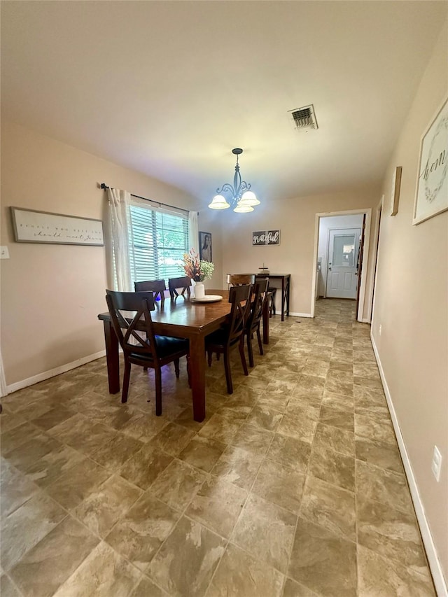 dining space with baseboards, visible vents, and a notable chandelier