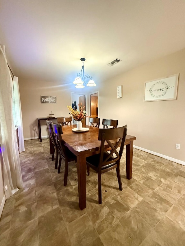 dining space featuring an inviting chandelier, visible vents, and baseboards