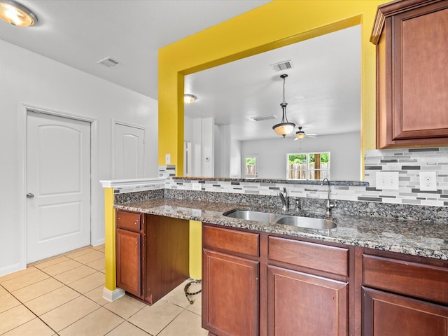 kitchen with tasteful backsplash, light tile patterned floors, a sink, visible vents, and a ceiling fan