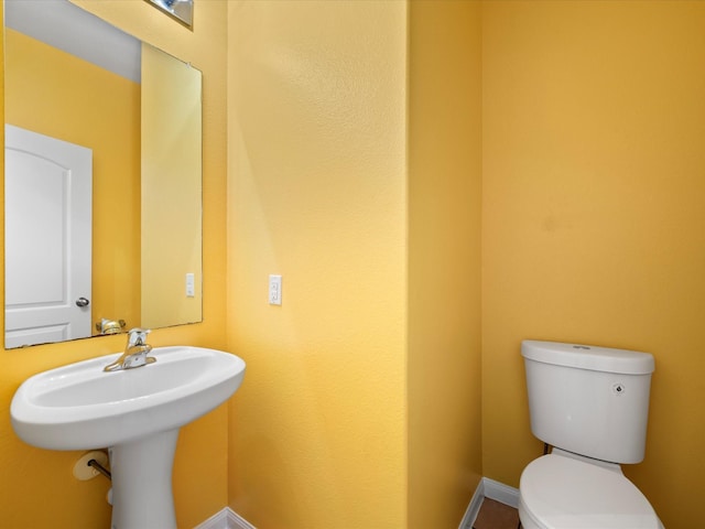 bathroom with toilet and baseboards
