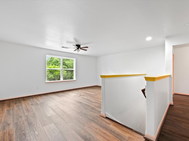 empty room featuring recessed lighting, ceiling fan, visible vents, baseboards, and wood finished floors